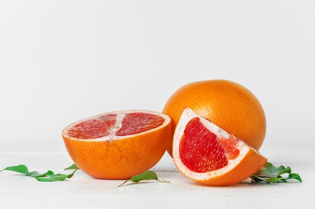 Grapefruit with slices on a wooden table.