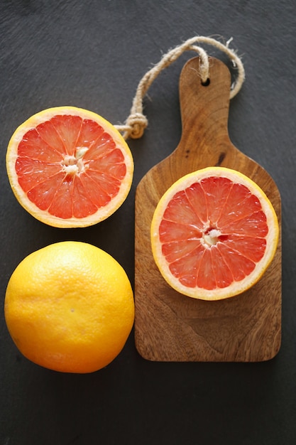 grapefruit on a wooden board on a black surface