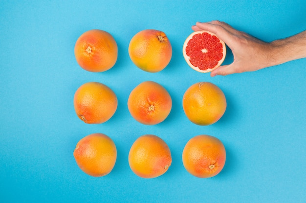 Foto grapefruits gerangschikt op blauwe platte achtergrond