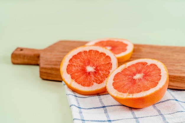 Grapefruitschijfjes op een houten bord op een groene achtergrond Het concept van gezonde voedingsvitamine