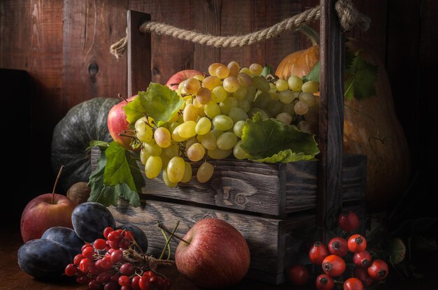 grapes and other fruits on a dark wooden background in a rustic style