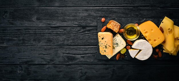 Grapes, red wine, cheeses, honey and nuts on a wooden background. Top view.