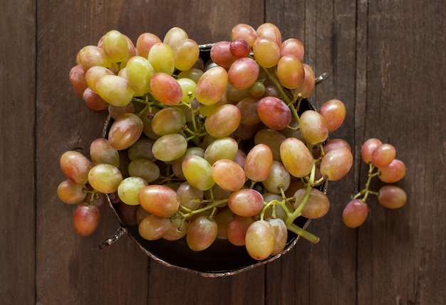 Grapes in silver bowl top view on wooden table