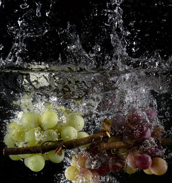 Grapes splashing into water