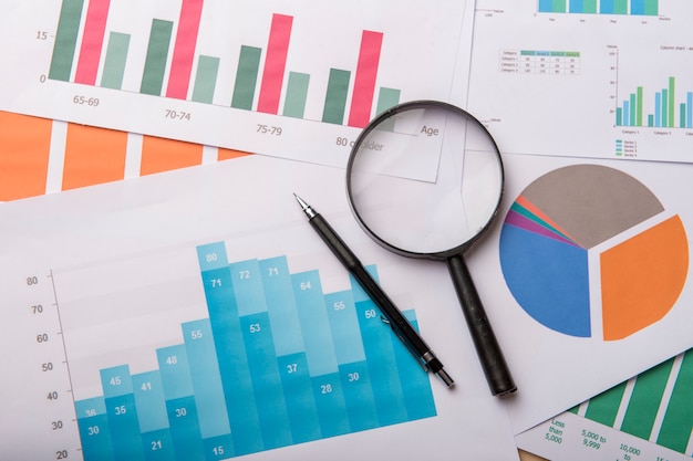 Photo graph and pie charts with pen and magnifier