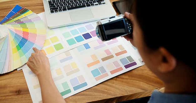 Graphic design and color swatches and pens on a desk.