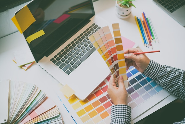 Креативная команда графического дизайнера в настоящее время работает над дизайном и выбором цвета для основного цвета для рекламного дизайна.