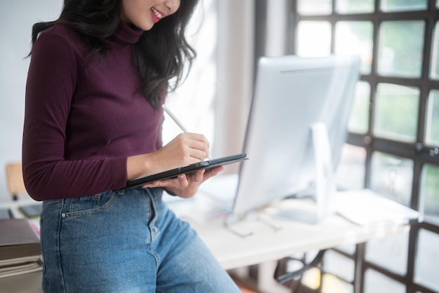 Graphic designer freelance women reading data to thinking creative ideas for logo brand while typing on computer and working to designing about graphic design with technology equipment in home studio