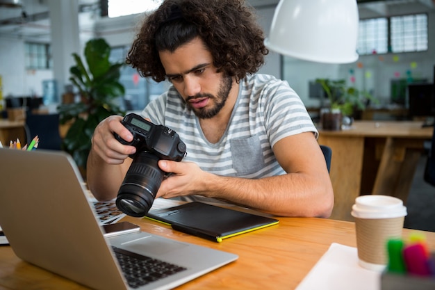 Graphic designer looking at pictures in digital camera