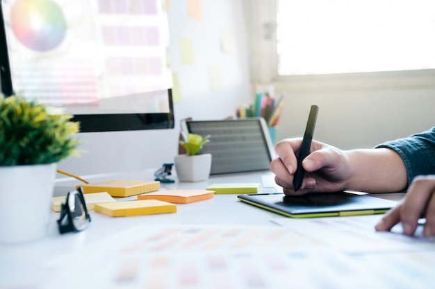 Graphic designer using graphics tablet to do work at desk