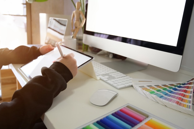 Foto graphic designer che lavora con tablet in un ambiente di lavoro creativo