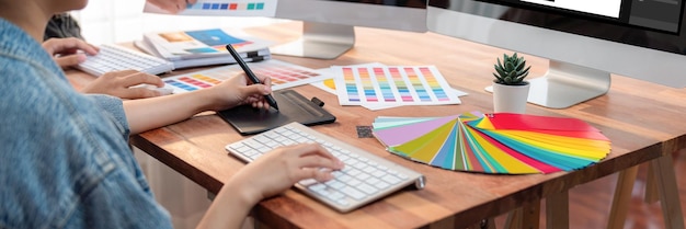 Graphic designer works on computer laptop with digital pen Scrutinize