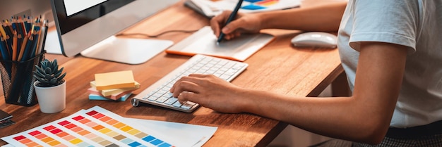 Graphic designer works on computer laptop with digital pen Scrutinize