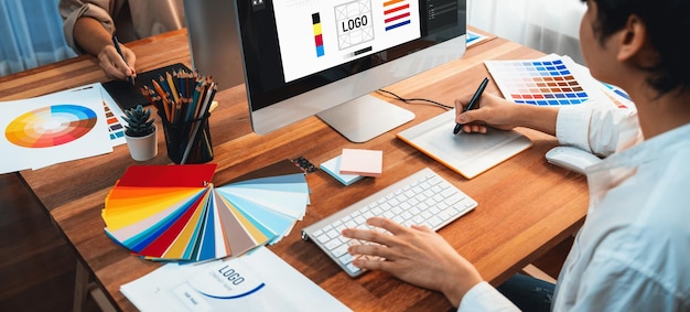 Graphic designer works on computer laptop with digital pen Scrutinize