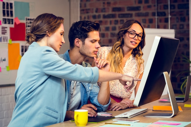 Graphic designers discussing over computer