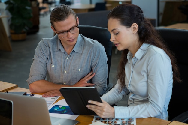 Graphic designers discussing over digital tablet