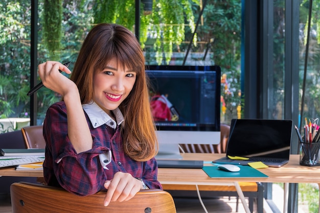 Graphic designers sit on chair in front of a desk full of tools