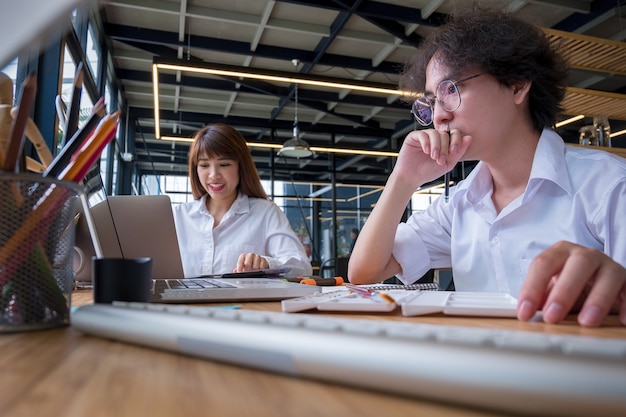 Graphic designers work together with computer and mouse pen 