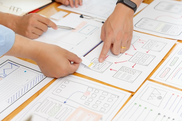 Foto i progettisti grafici collaborano con il framework di layout del modello di applicazione per la pianificazione dell'interfaccia utente ux designer per il cellulare