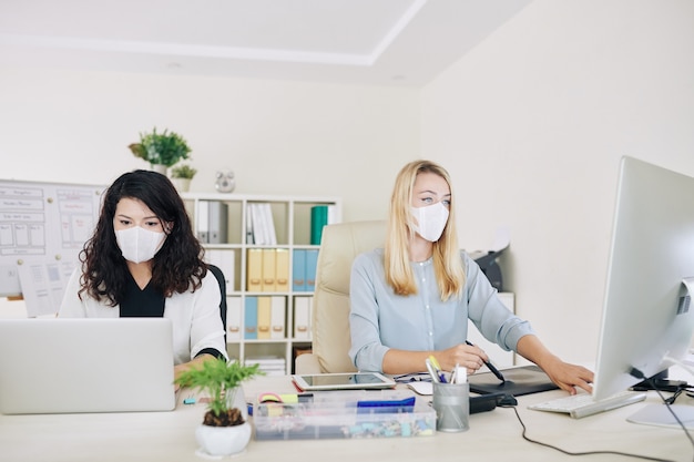 Graphic designers working in medical masks