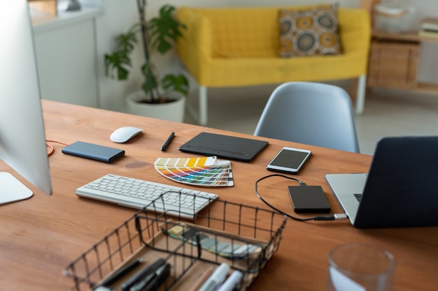Рабочее место графического дизайнера с образцом цвета, дигитайзером, смартфоном и компьютерами в домашнем офисе