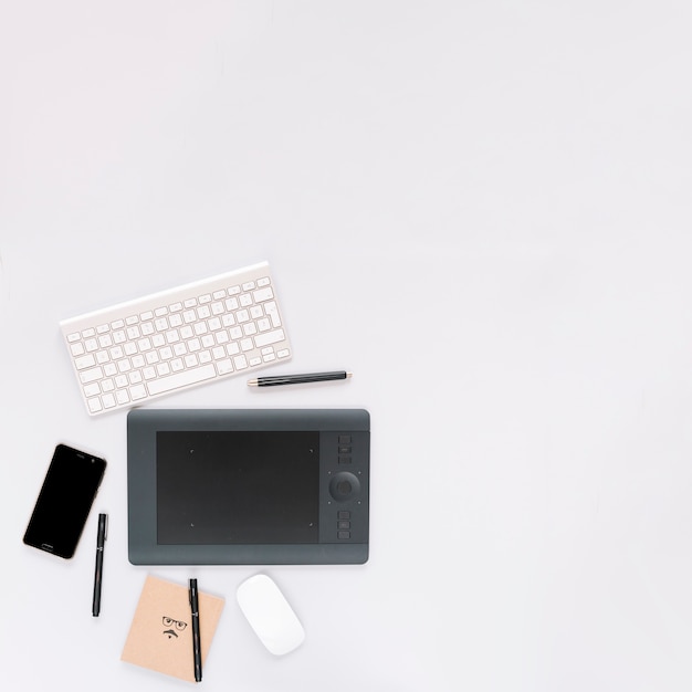 Фото Графический цифровой планшет; клавиатура; мышь и мобильный телефон с ручкой на белом фоне