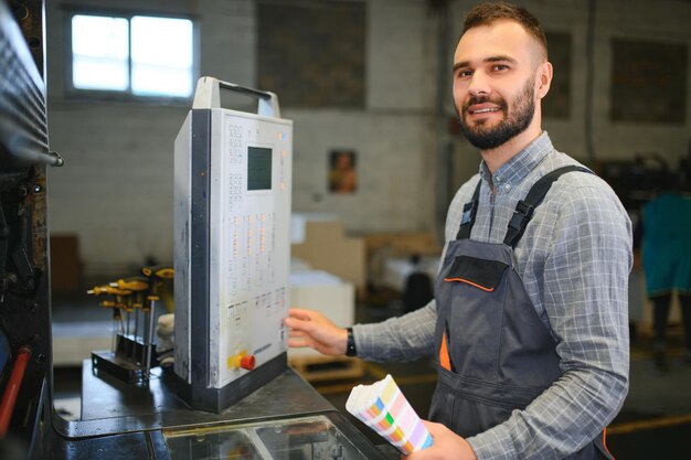 Graphic engineer or worker checking imprint quality in modern print shop