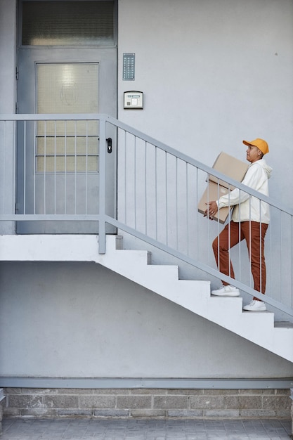 Graphic minimal shot of delivery man going up stairs to house\
door