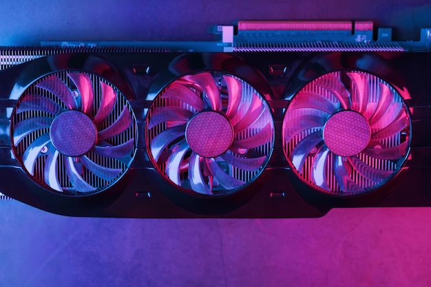 A graphics card with a row of fans with a cyanotic purple backlight 