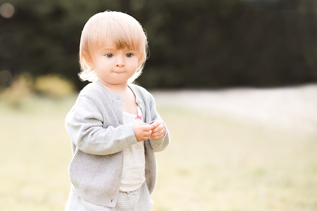 Foto grappig babymeisje dat buiten in het park loopt