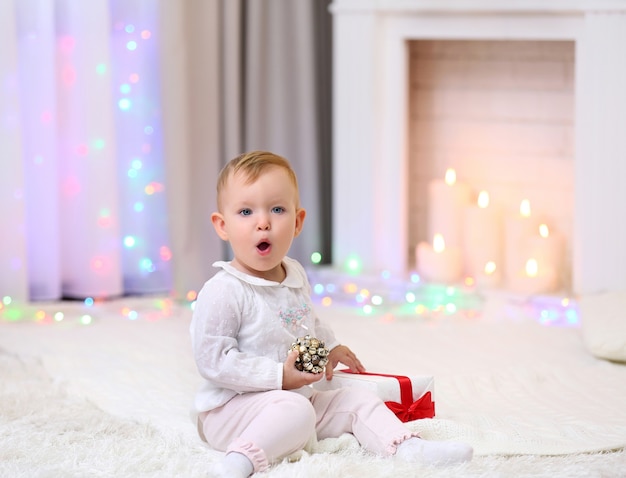 Grappig babymeisje in de woonkamer van Kerstmis