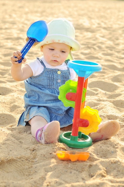 Foto grappig babymeisje speelt met zand