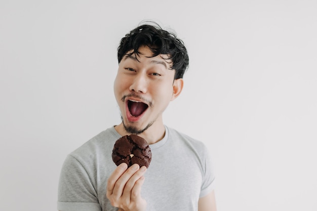 Grappig gezicht man eet chocoladekoekje geïsoleerd op een witte achtergrond