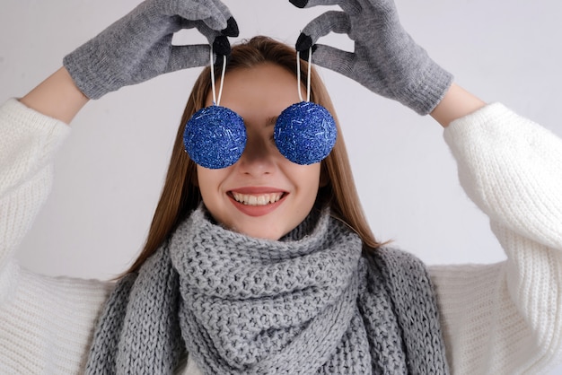 Grappig jong model met Kerstmis decoratieve ballen op haar ogen