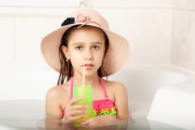 Grappig Kaukasisch mooi meisje in hoed speelt thuis het strand baden