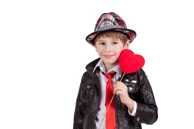 Grappig kind in een elegante hoed houdt een hart vast Jongen met een Valentijn