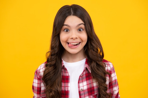 Grappig kindergezicht Portret van een dwaas tienerkindmeisje dat lacht en tong in de camera laat zien en grappige gezichten maakt