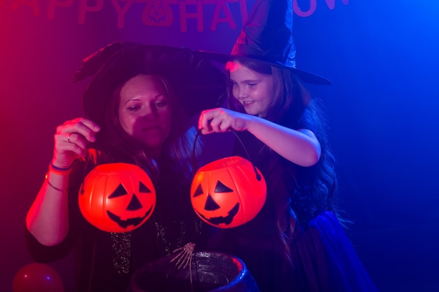 Grappig kindmeisje en vrouw in heksenkostuums voor halloween