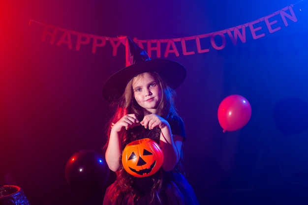 Grappig kindmeisje in heksenkostuum voor halloween met pompoenjack