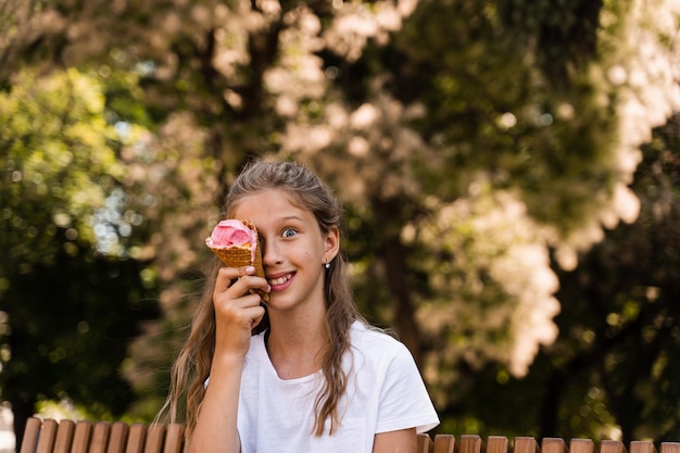 Grappig kindmeisje veel plezier met ijshoorntje in wafelkop Gelukkig meisje glimlachend lachen en grimassen Creatieve advertentie voor ijskraam en winkel