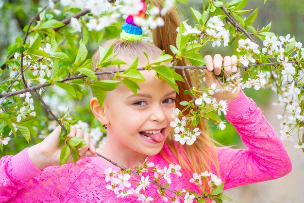 Grappig lachend tienermeisje met Lentebloemen. Komische grimas, grappige emotie, gekke gezichtsbehandeling.