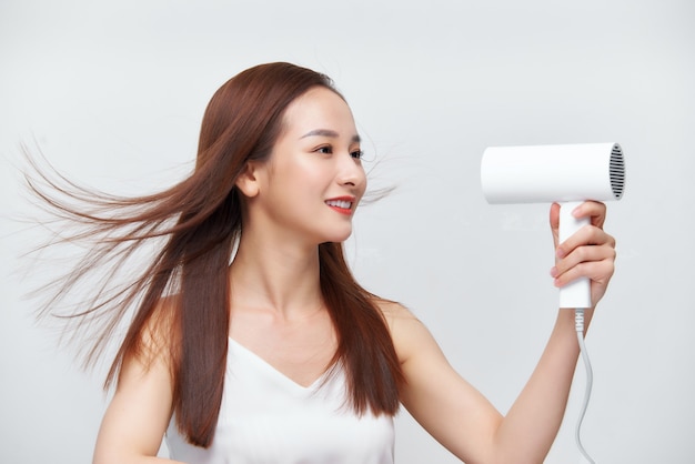 Grappig meisje dat haar pas gewassen haar droogt en in de spiegel kijkt