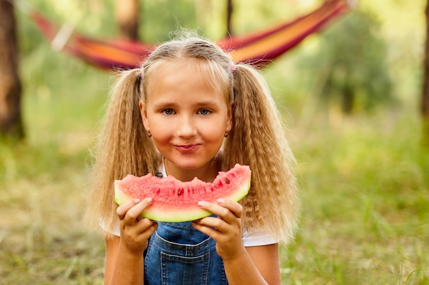 Grappig meisje dat watermeloen eet in het park