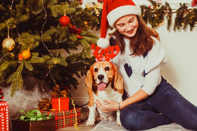 Grappig meisje en hond wachten thuis op het nieuwe jaar Fijne kerstvakantie