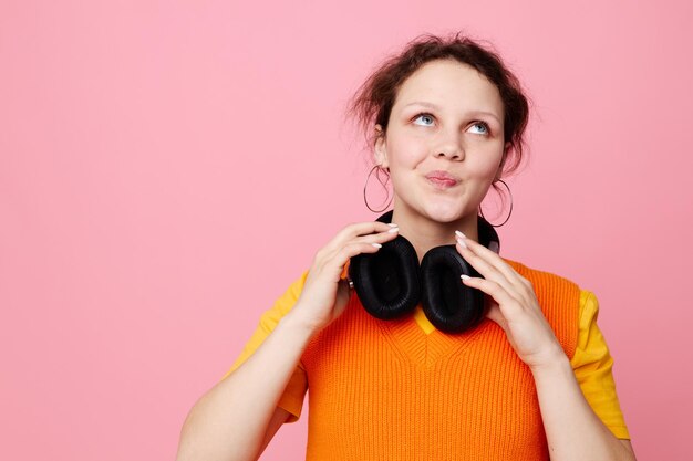 Grappig meisje in een oranje jasje hoofdtelefoon muziek entertainment levensstijl ongewijzigd