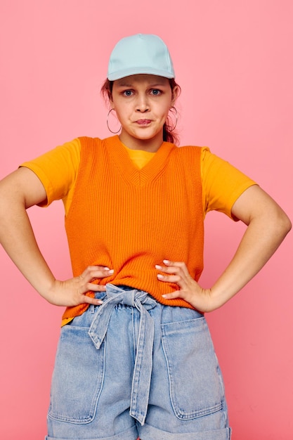 Grappig meisje in een oranje trui in blauwe hoofdletters handgebaar levensstijl ongewijzigd