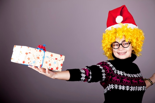 Foto grappig meisje in glazen met kerstcadeaus. studio opname.