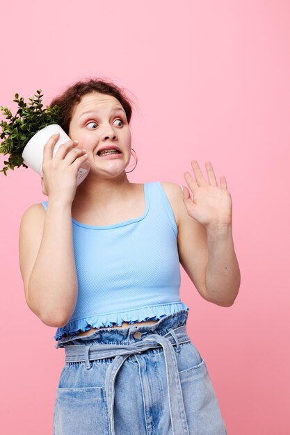 Grappig meisje ingemaakte bloem poseren plant roze achtergrond ongewijzigd