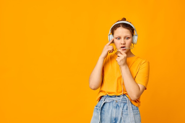 Grappig meisje luisteren naar muziek op koptelefoon jeugd stijl gele achtergrond ongewijzigd