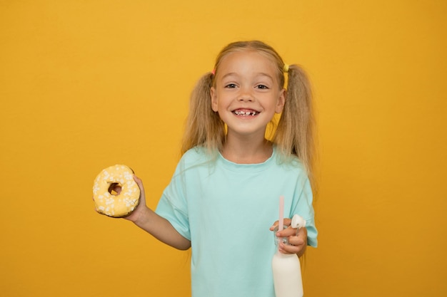 Grappig meisje met donuts op een gele achtergrond